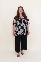 black with light floral chiffon blouse worn by model