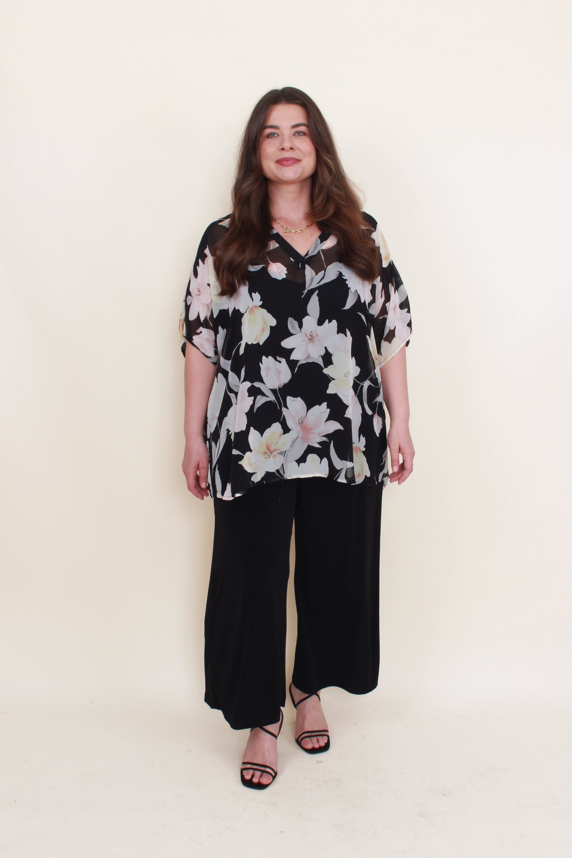 black with light floral chiffon blouse worn by model