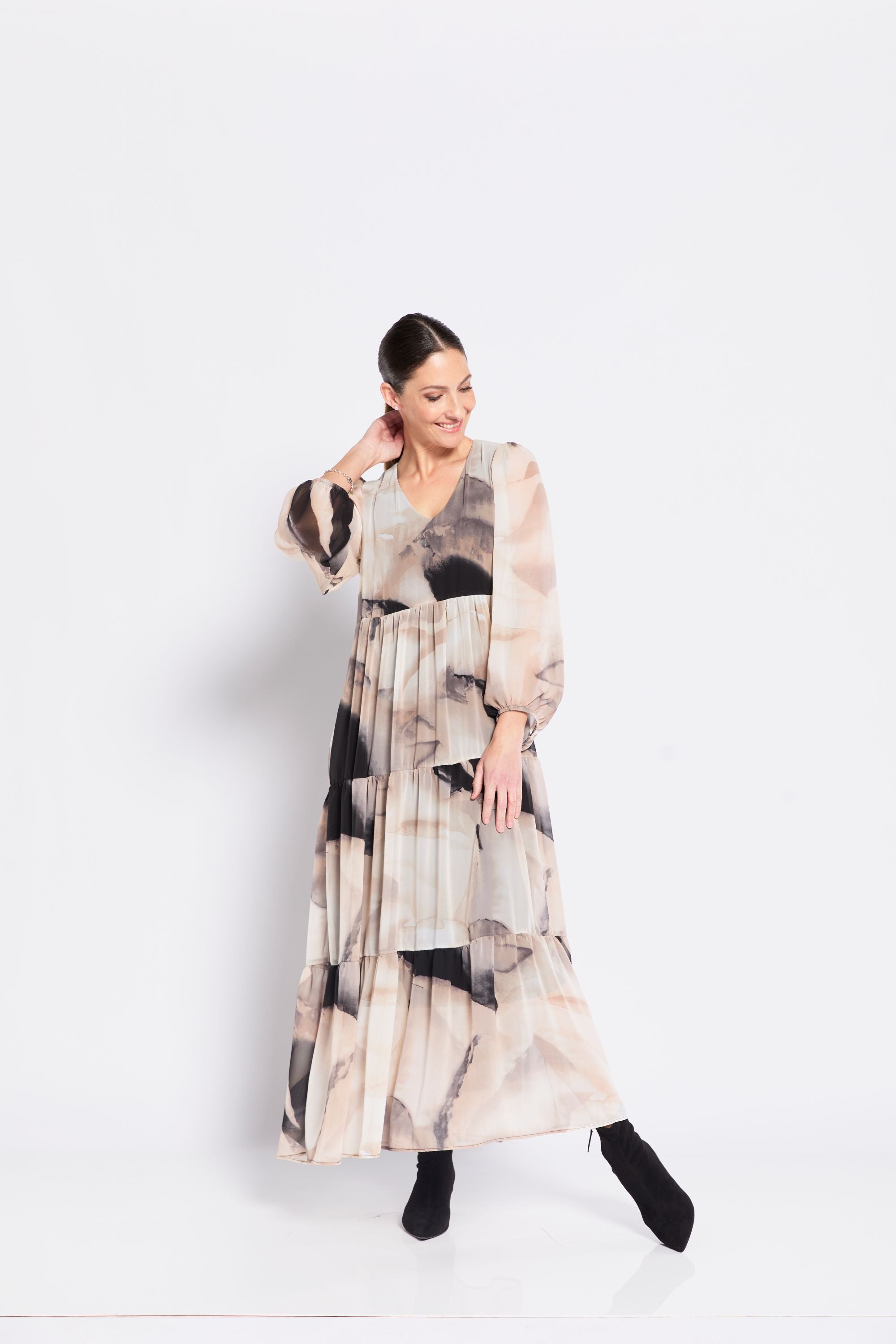 Woman wearing a long, patterned dress on a white background