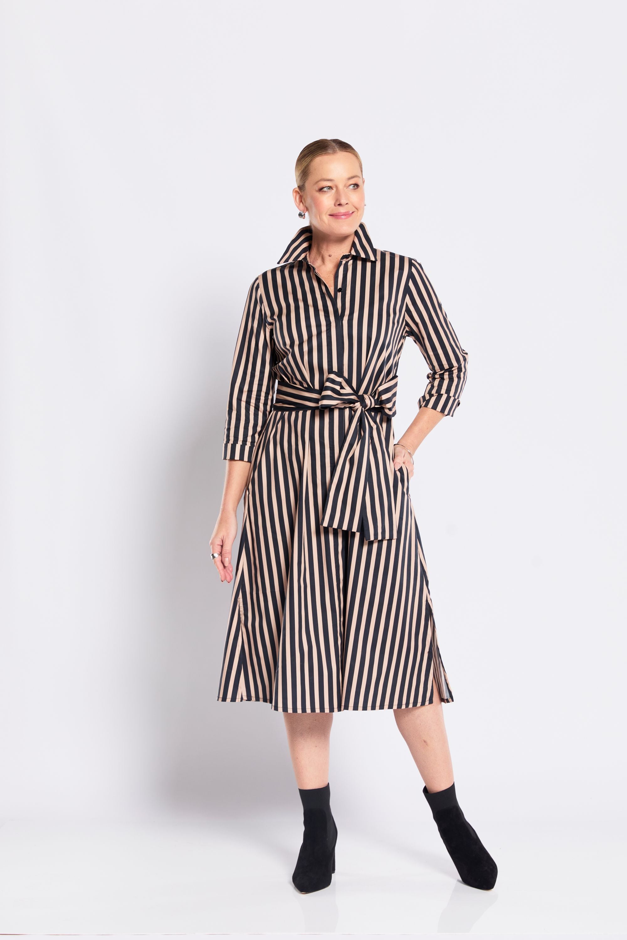 Woman wearing a black and beige striped dress on a white background