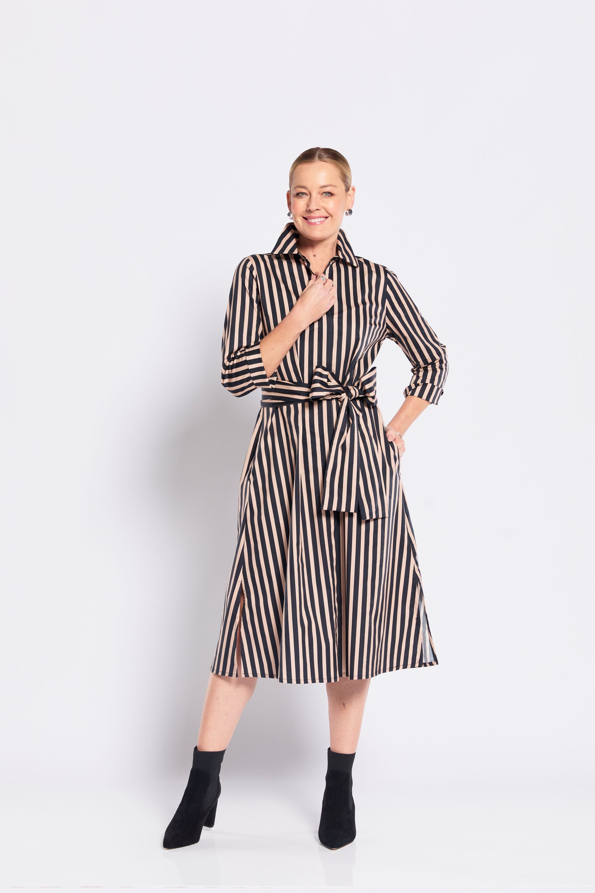 Woman wearing a black and beige striped dress on a white background