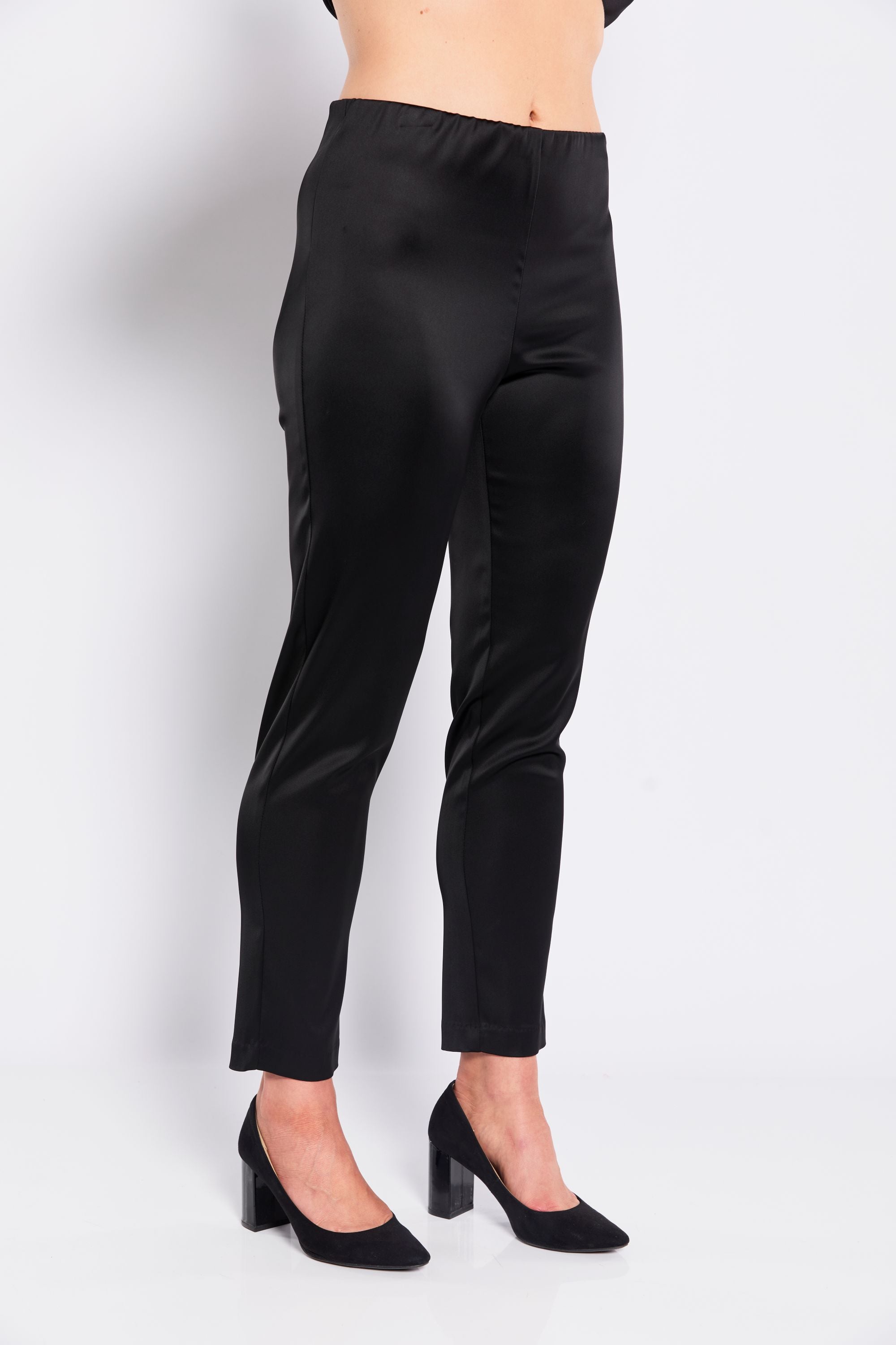 Black satin pants worn by a person on a white background