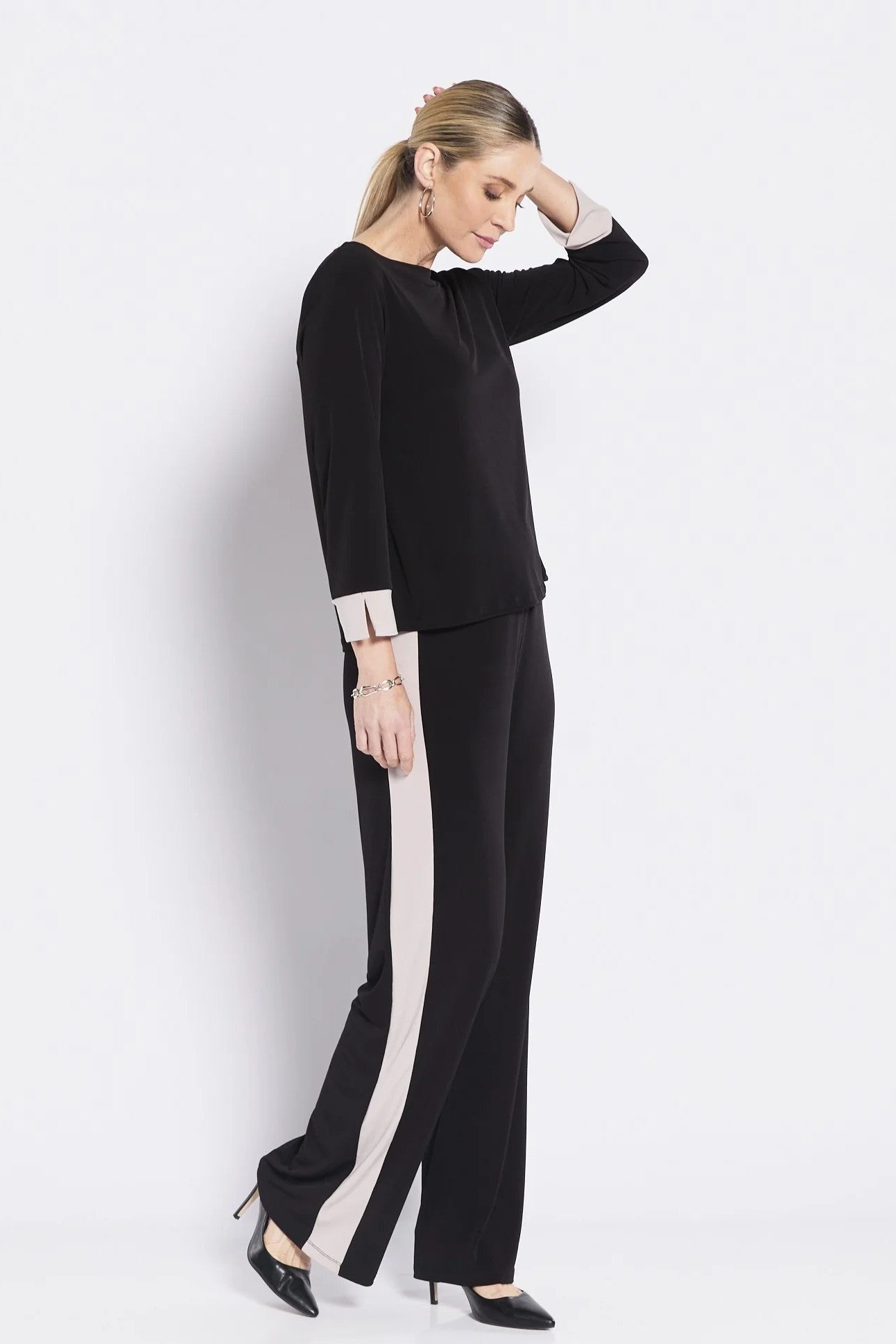 Woman wearing a black outfit with white stripes on a white background