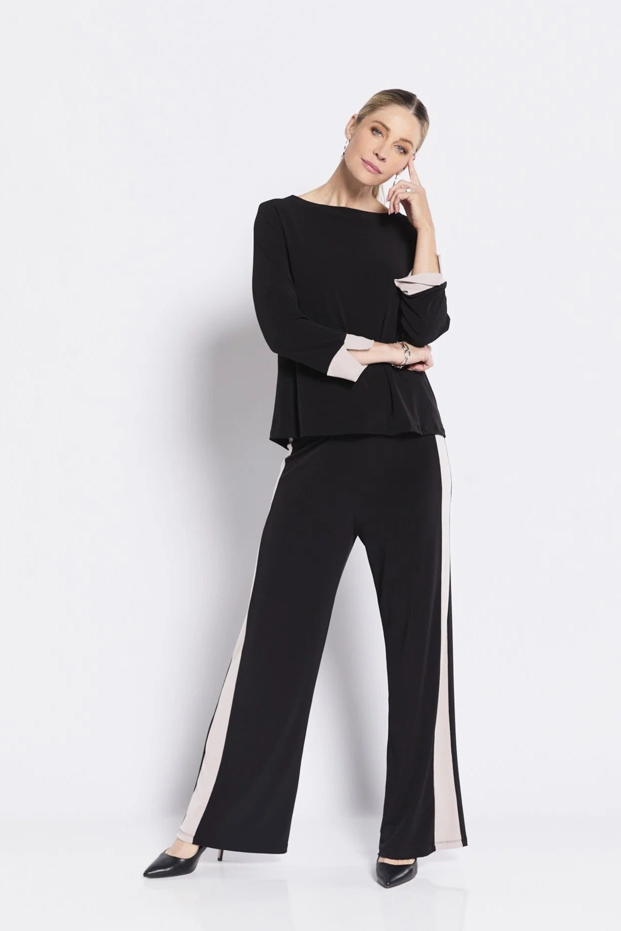 Woman wearing a black outfit with white stripes on a white background