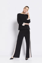 Woman wearing a black outfit with white stripes on a white background