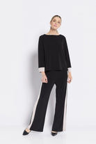 Woman wearing a black outfit with white trim on a white background