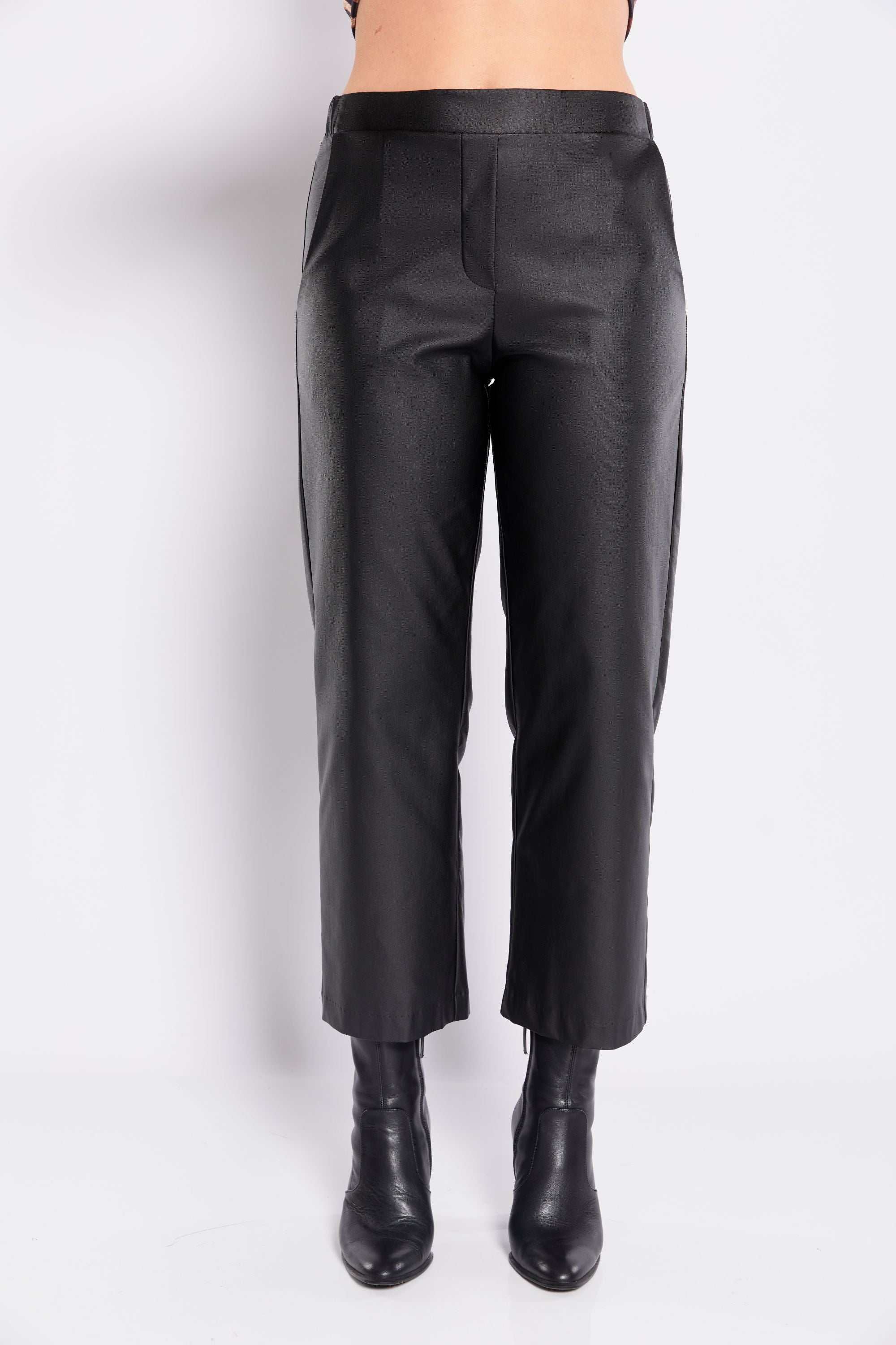 Black leather pants worn by a person on a white background