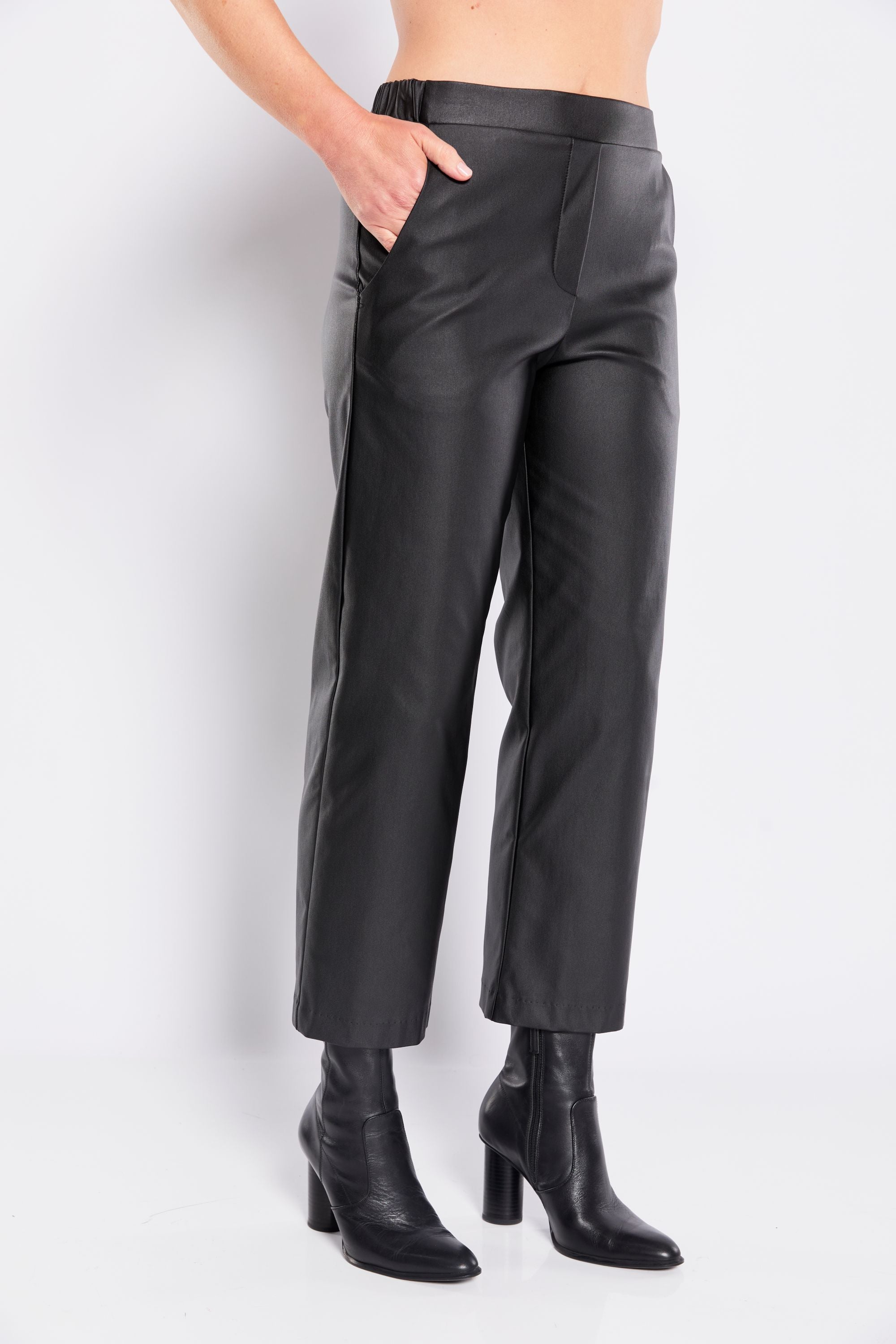 Black leather pants worn by a person on a white background