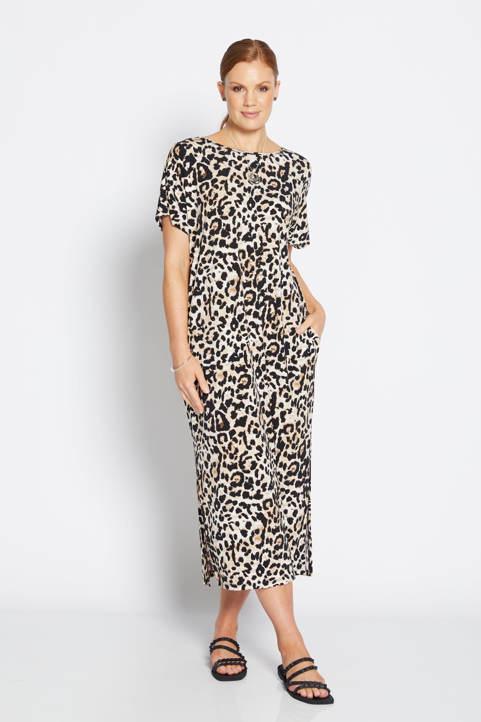 Woman wearing a leopard print dress on a white background