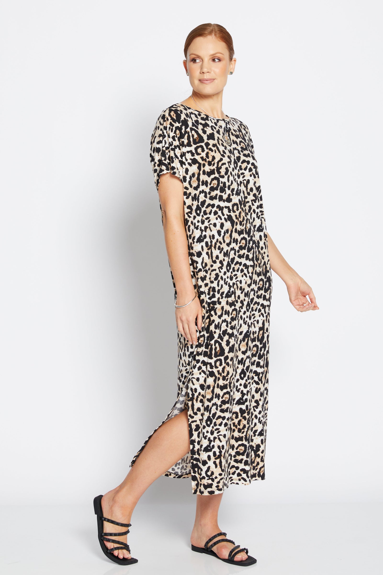 Woman wearing a leopard print dress on a white background