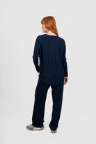 Person wearing a navy long-sleeve top and pants on a white background