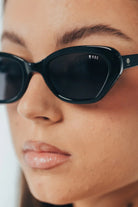Close-up of a person wearing black sunglasses with 'ROC' branding.