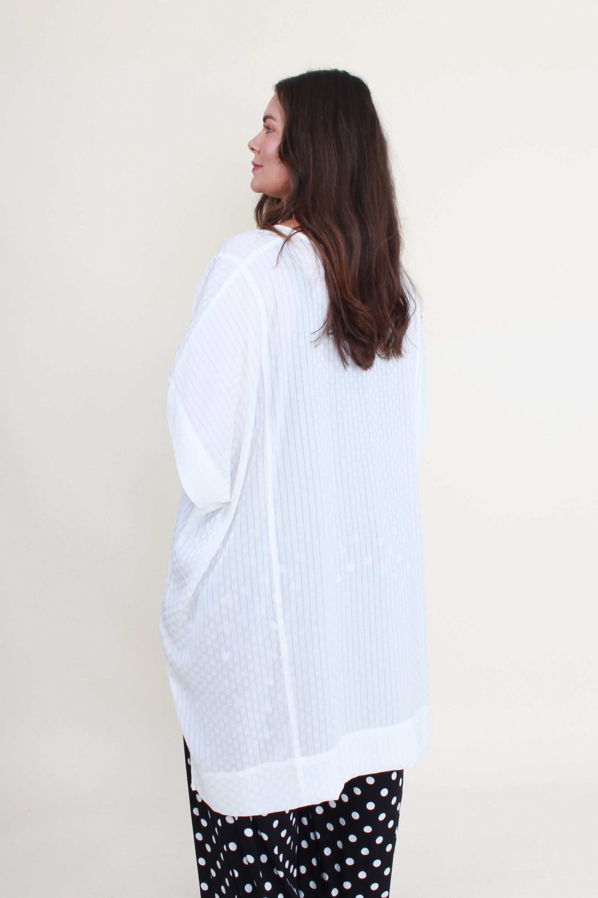 Woman wearing a white blouse on a plain background