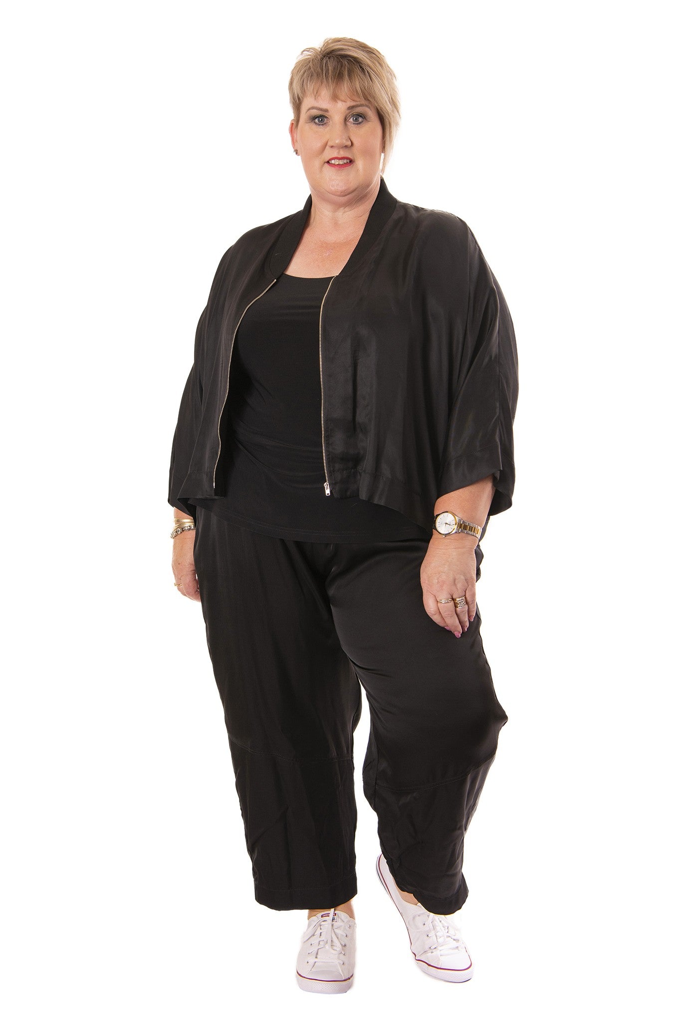Woman wearing a black outfit with a jacket and pants on a white background