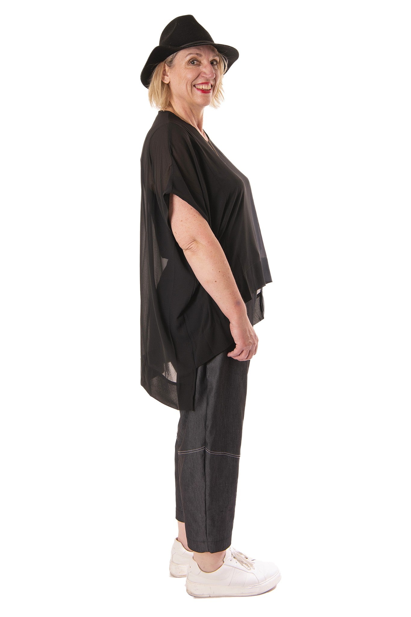 Woman wearing a black outfit with a hat on a white background