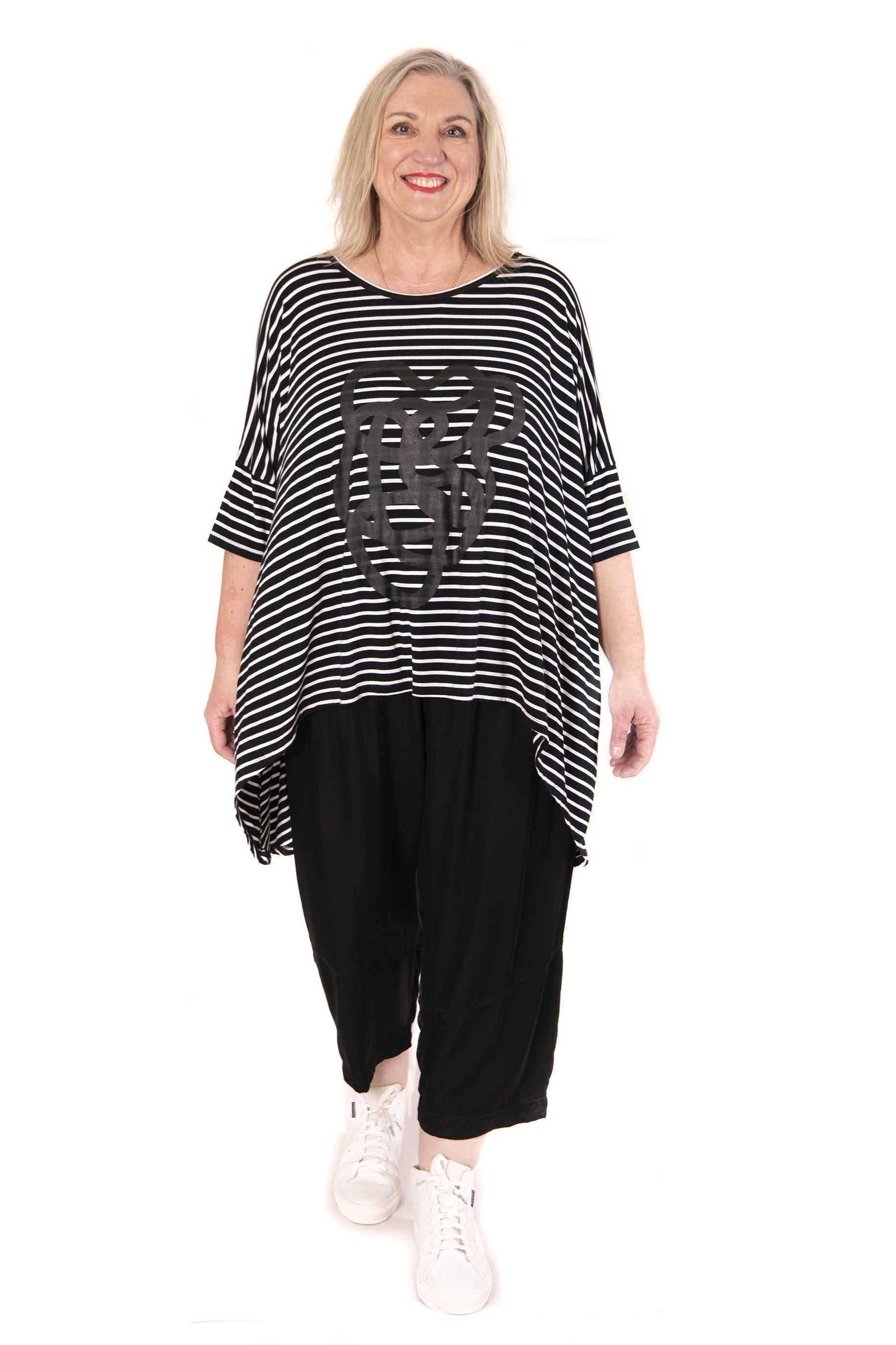 Woman wearing a black and white striped top with squiggle design on a white background