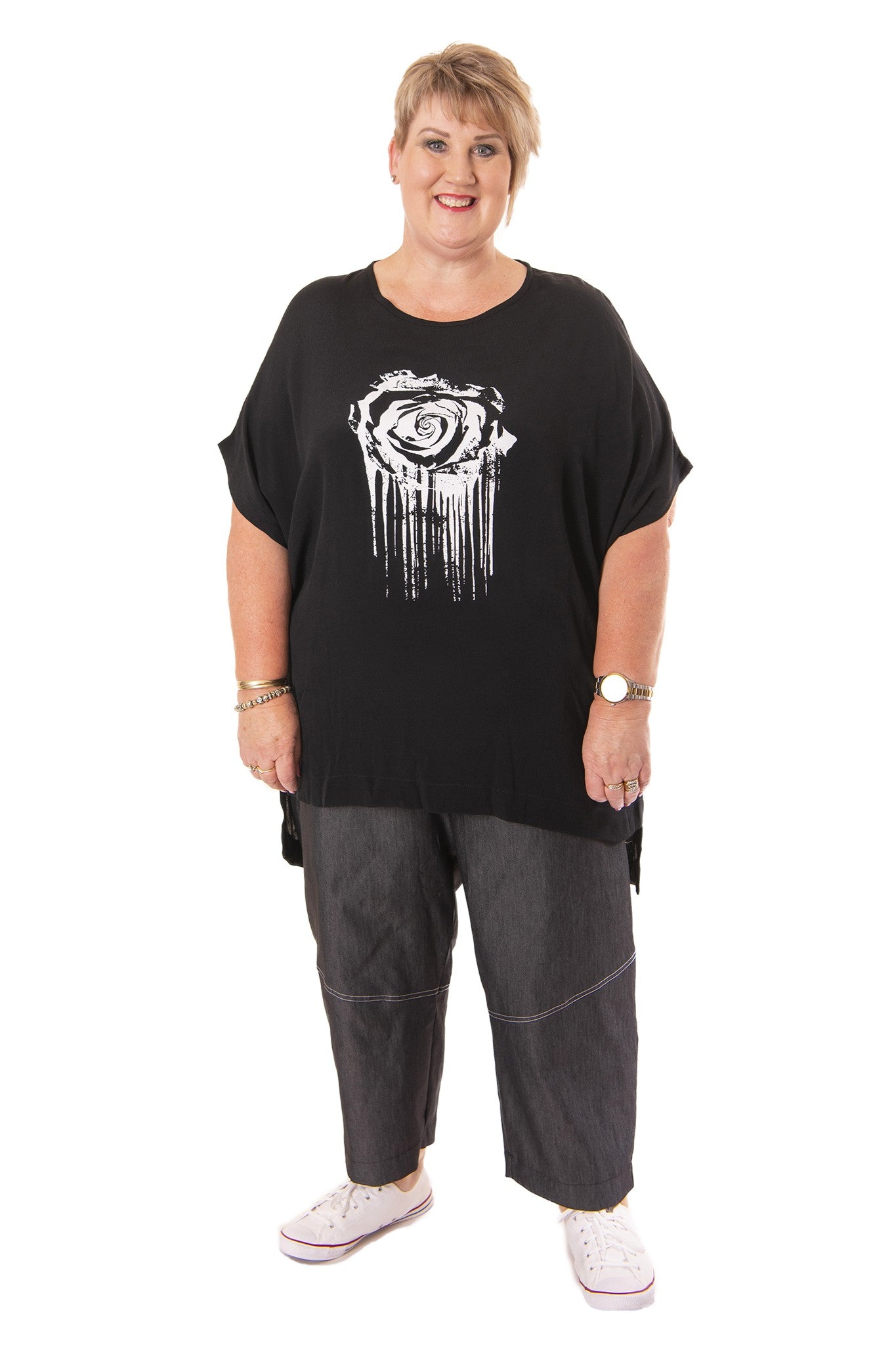 Person wearing a black oversized t-shirt with a white graphic design on a white background