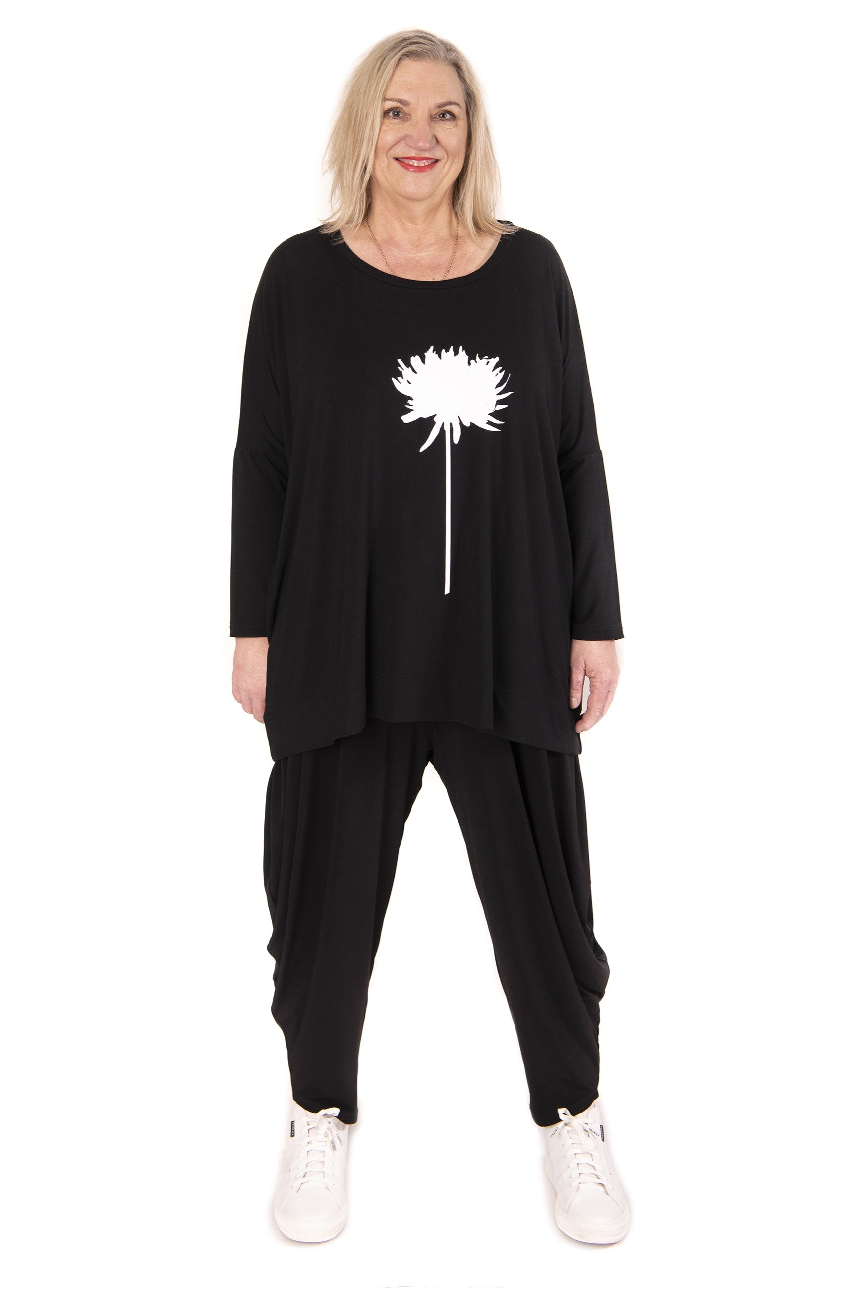 Woman wearing a black outfit with a white floral design on a white background