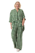 Woman wearing a green and white checkered outfit on a white background