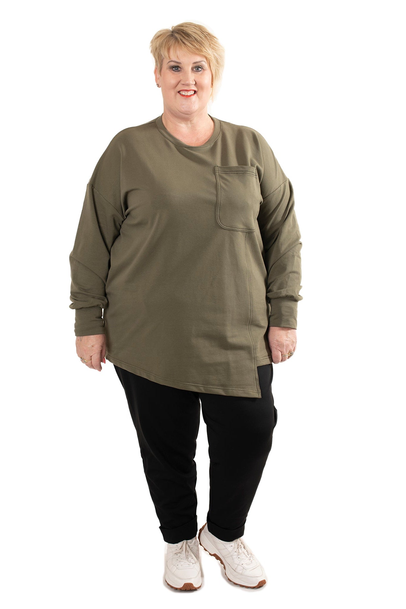 Person wearing a green long-sleeve shirt and black pants on a white background