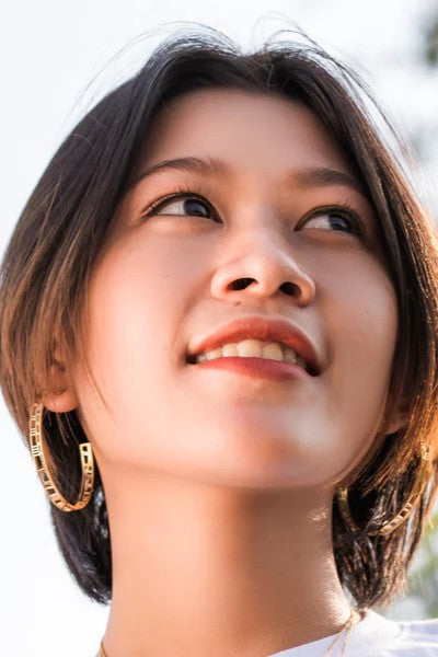 gold hoops earrings with map and clock details on ear