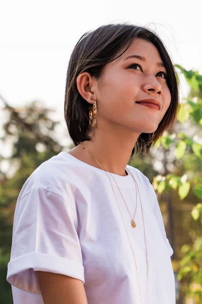 gold hoops earrings with map and clock details on ear