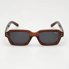 Sunglasses with brown frame and dark lenses on a white background