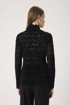Black lace top worn by a model on a white background back angle