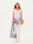 Woman wearing a white outfit with floral accessories on a white background