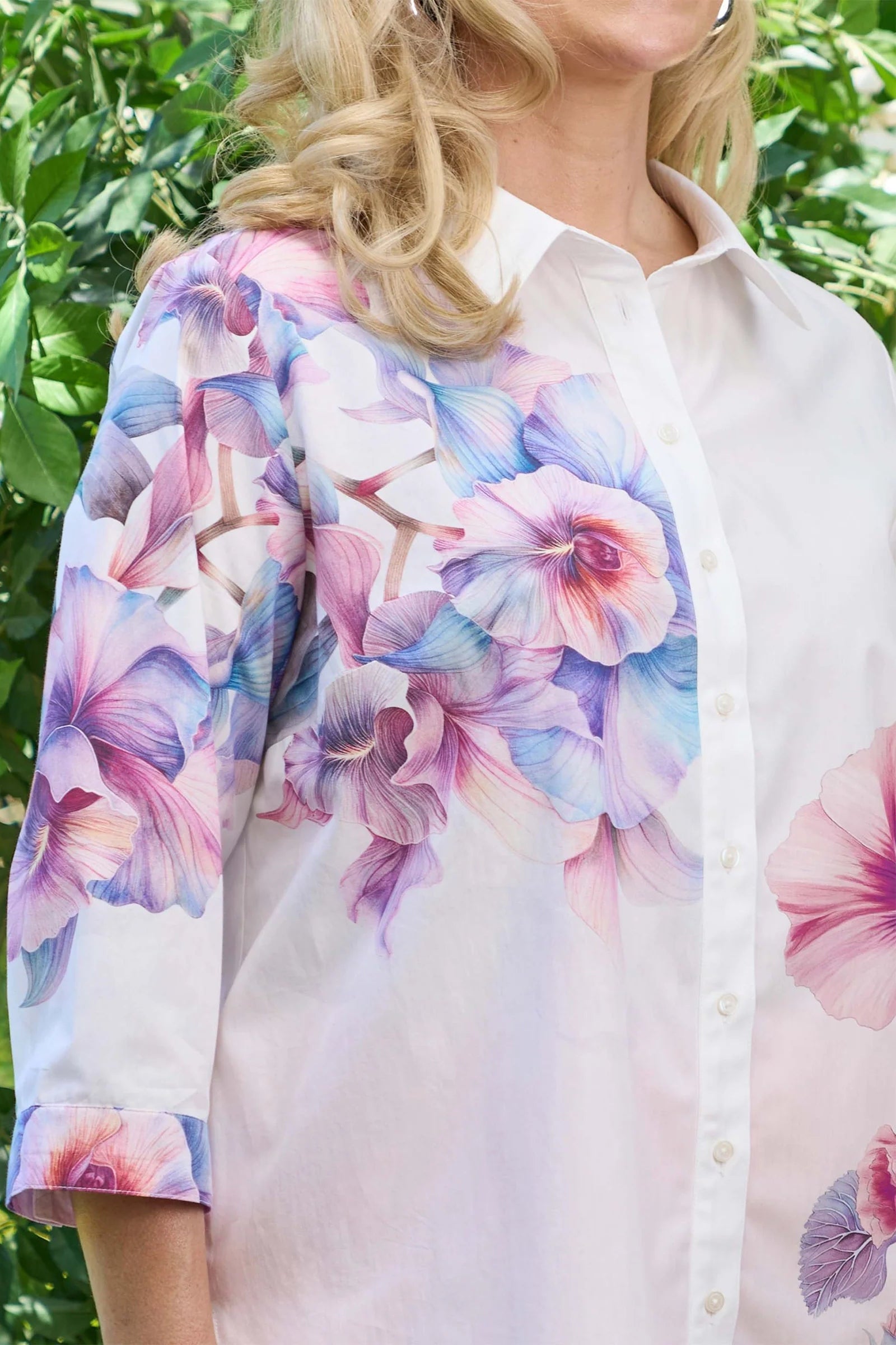 Woman wearing a floral blouse with a blurred green background