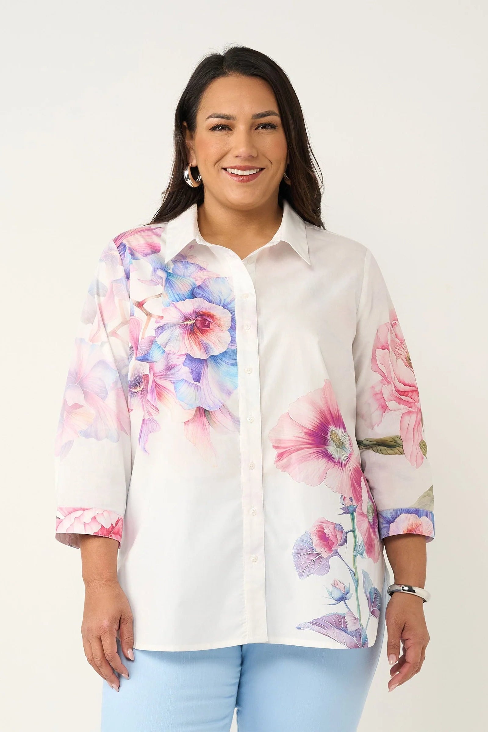 Woman wearing a white shirt with colorful floral sleeves on a white background