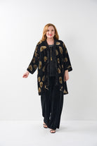 Woman wearing a black outfit with gold patterns on a white background