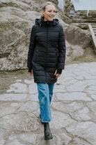 Woman wearing a black longline puffer coat outdoors