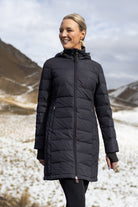 Woman wearing a black puffer coat in a snowy mountain landscape
