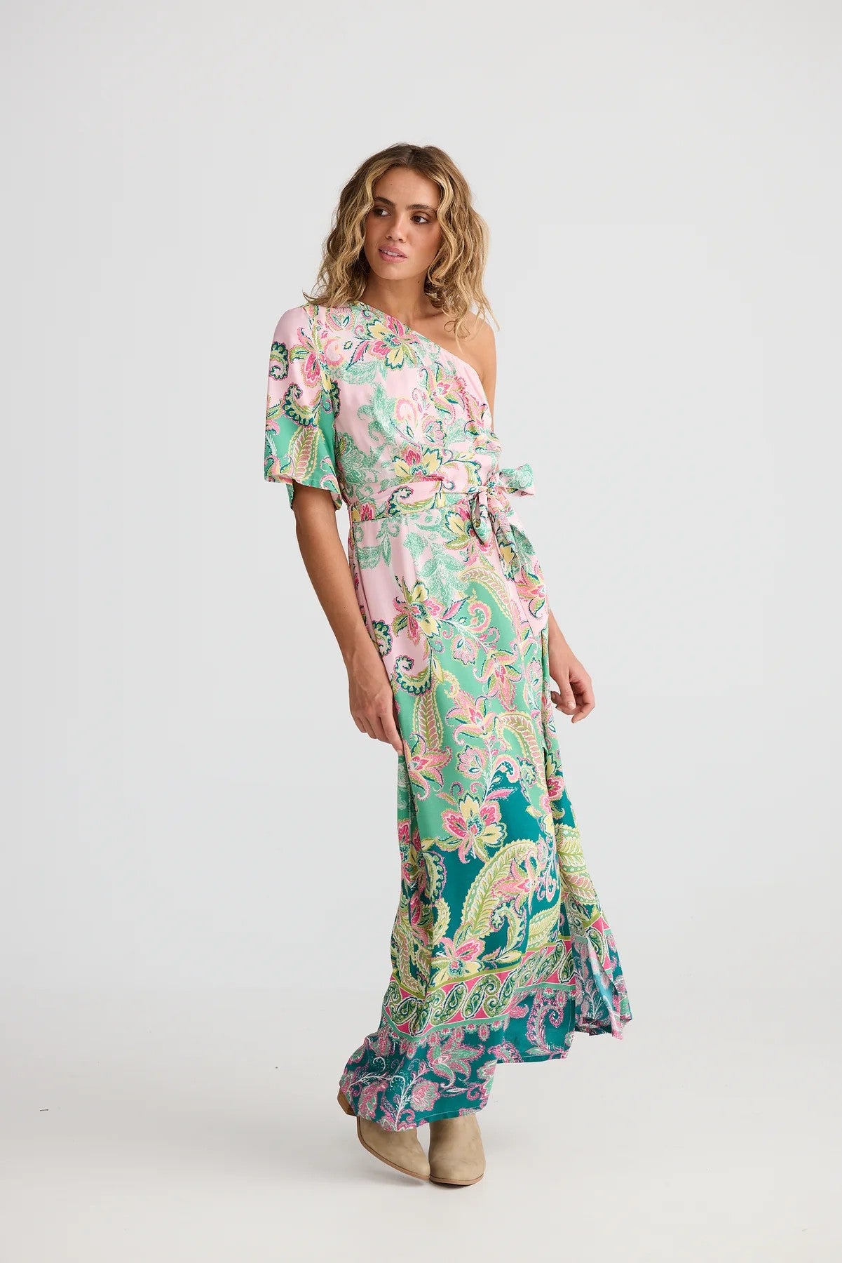 Woman wearing a floral one-shoulder dress on a white background