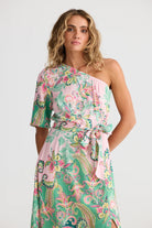 Woman wearing a floral one-shoulder dress on a white background