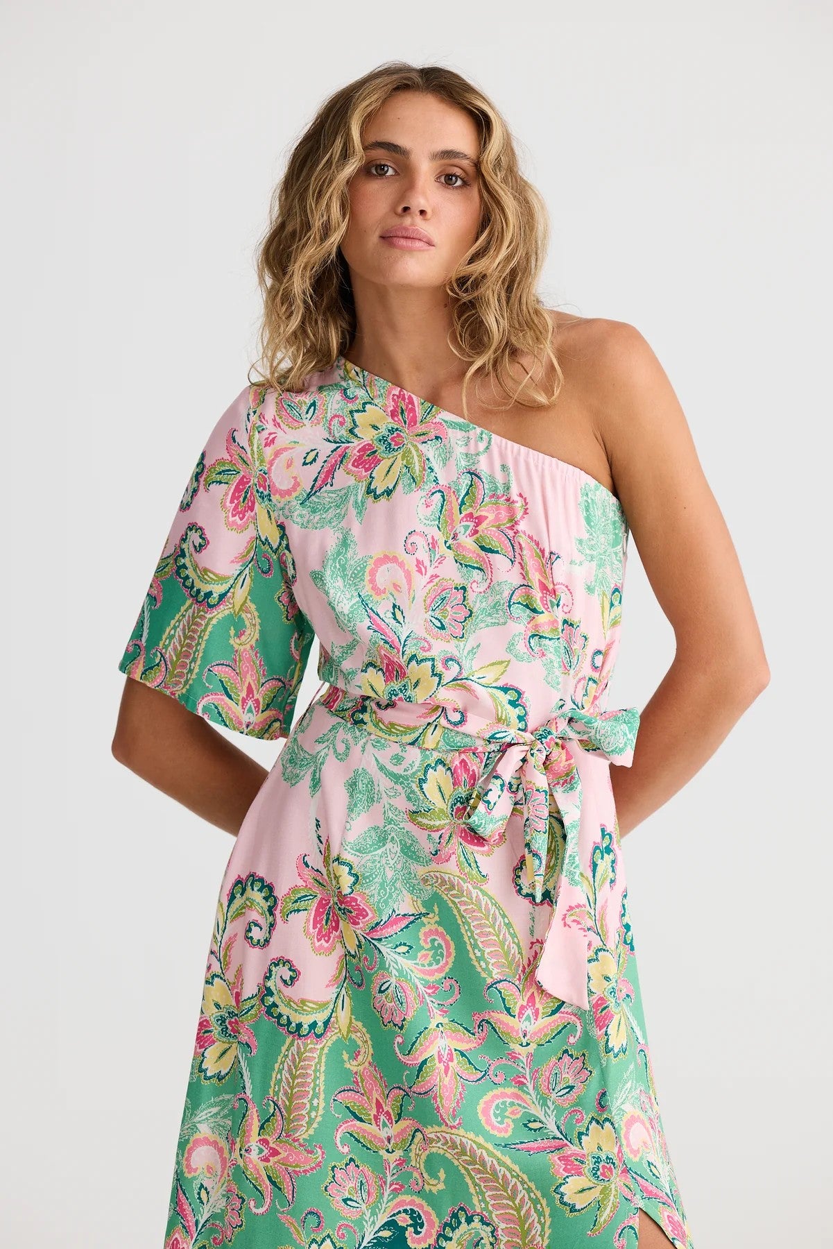 Woman wearing a floral one-shoulder dress on a white background