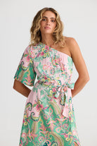 Woman wearing a floral one-shoulder dress on a white background