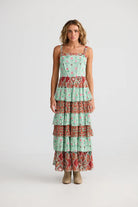 Woman wearing a tiered dress with a floral pattern on a white background