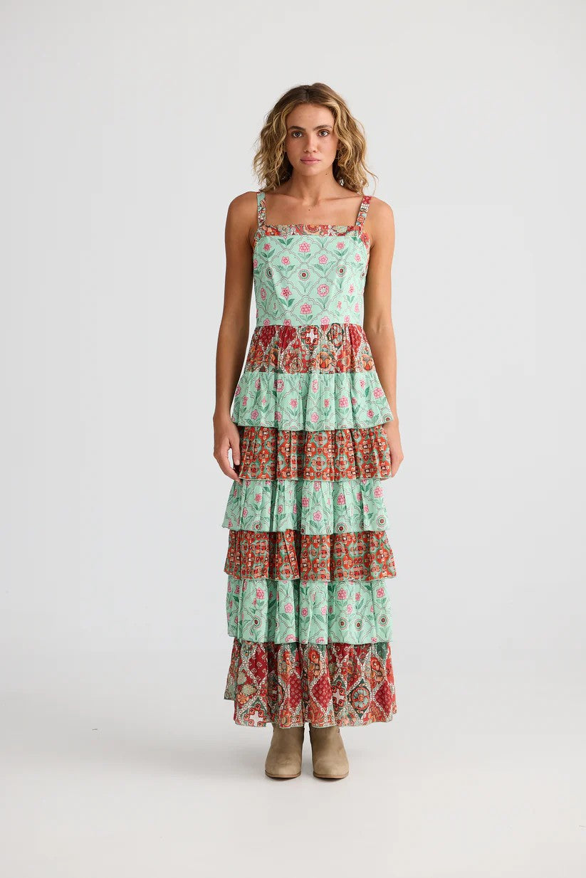 Woman wearing a tiered dress with a floral pattern on a white background