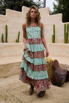 Woman wearing a layered dress with a desert landscape and cacti in the background