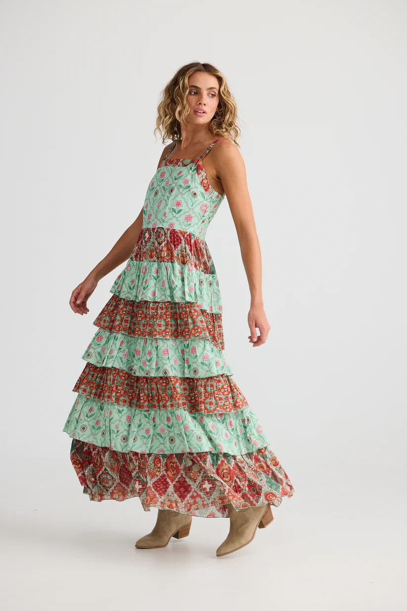 Woman wearing a tiered floral dress on a white background