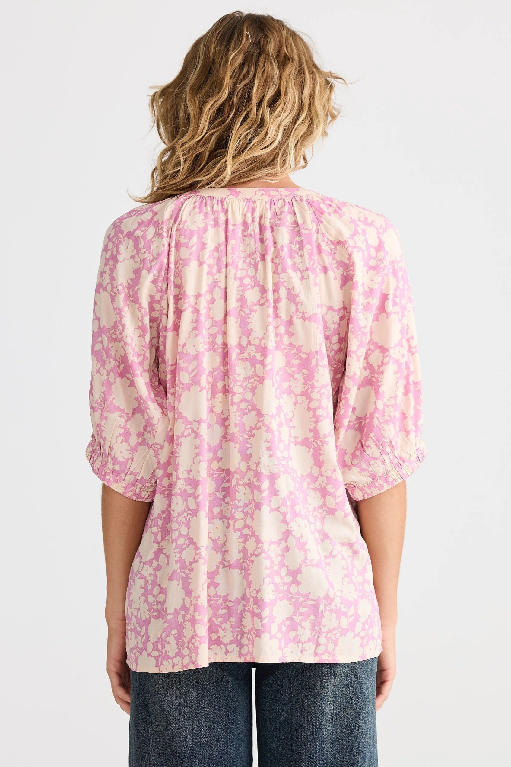 pink cream floral blouse and jeans worn by model back