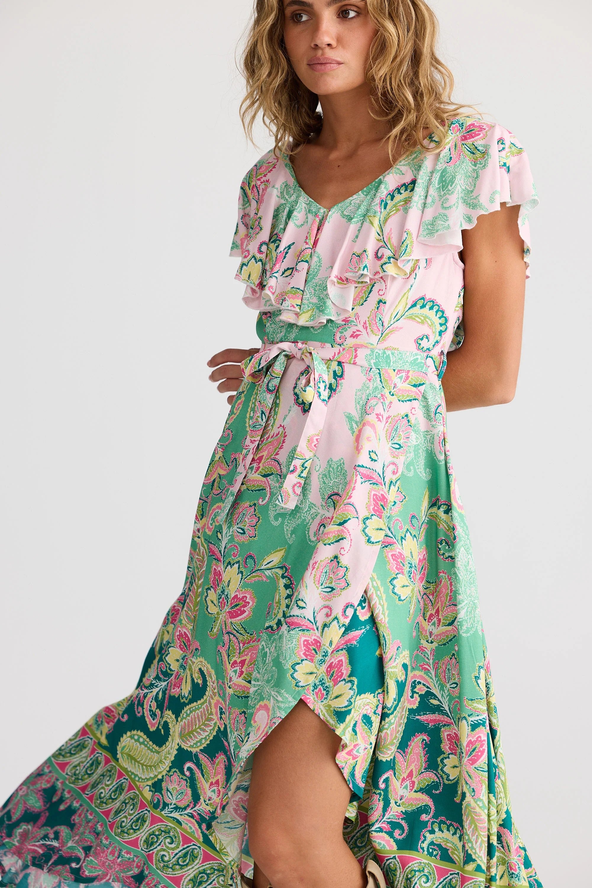 Woman wearing a colorful floral dress on a white background