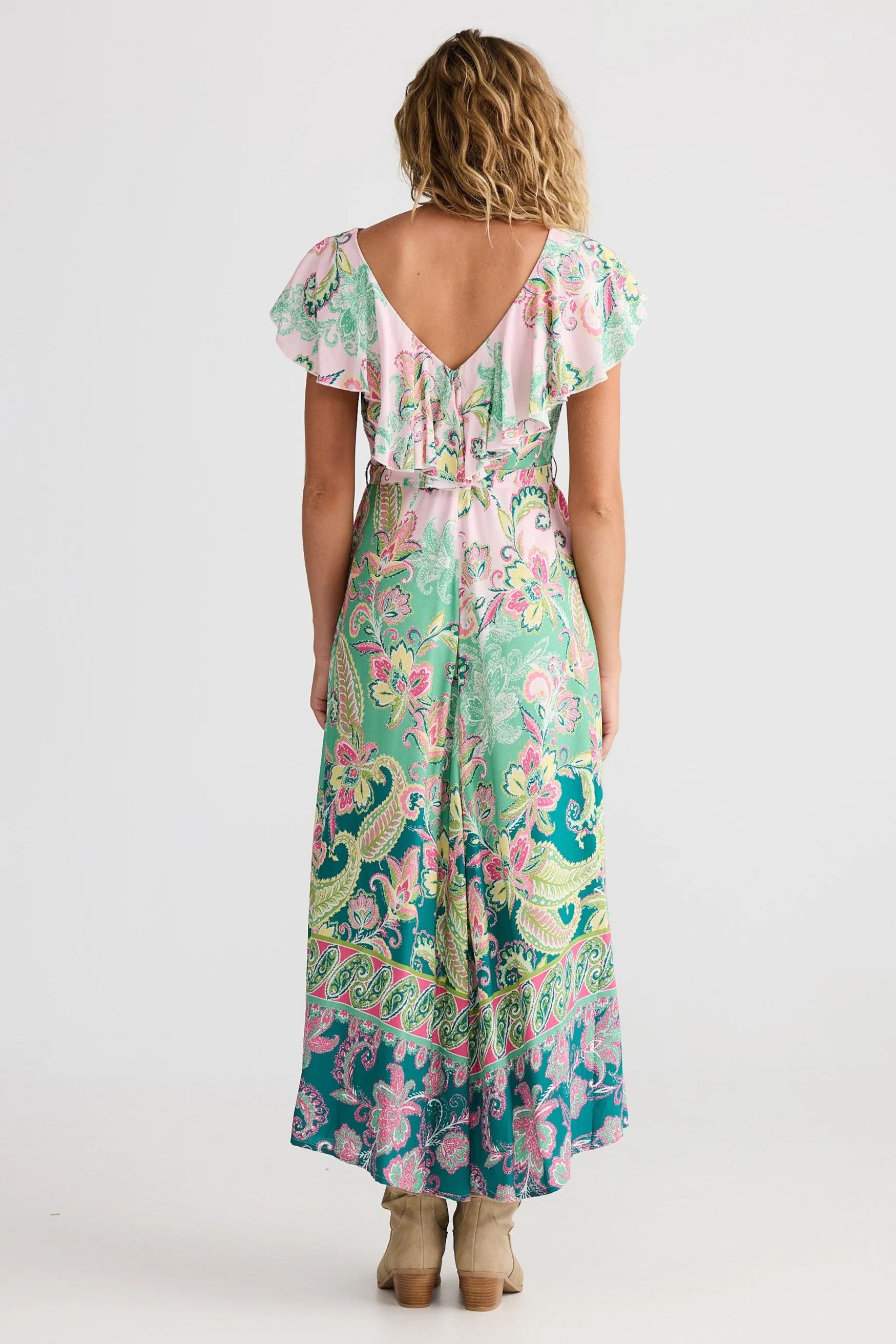 Woman wearing a floral dress with a white background back