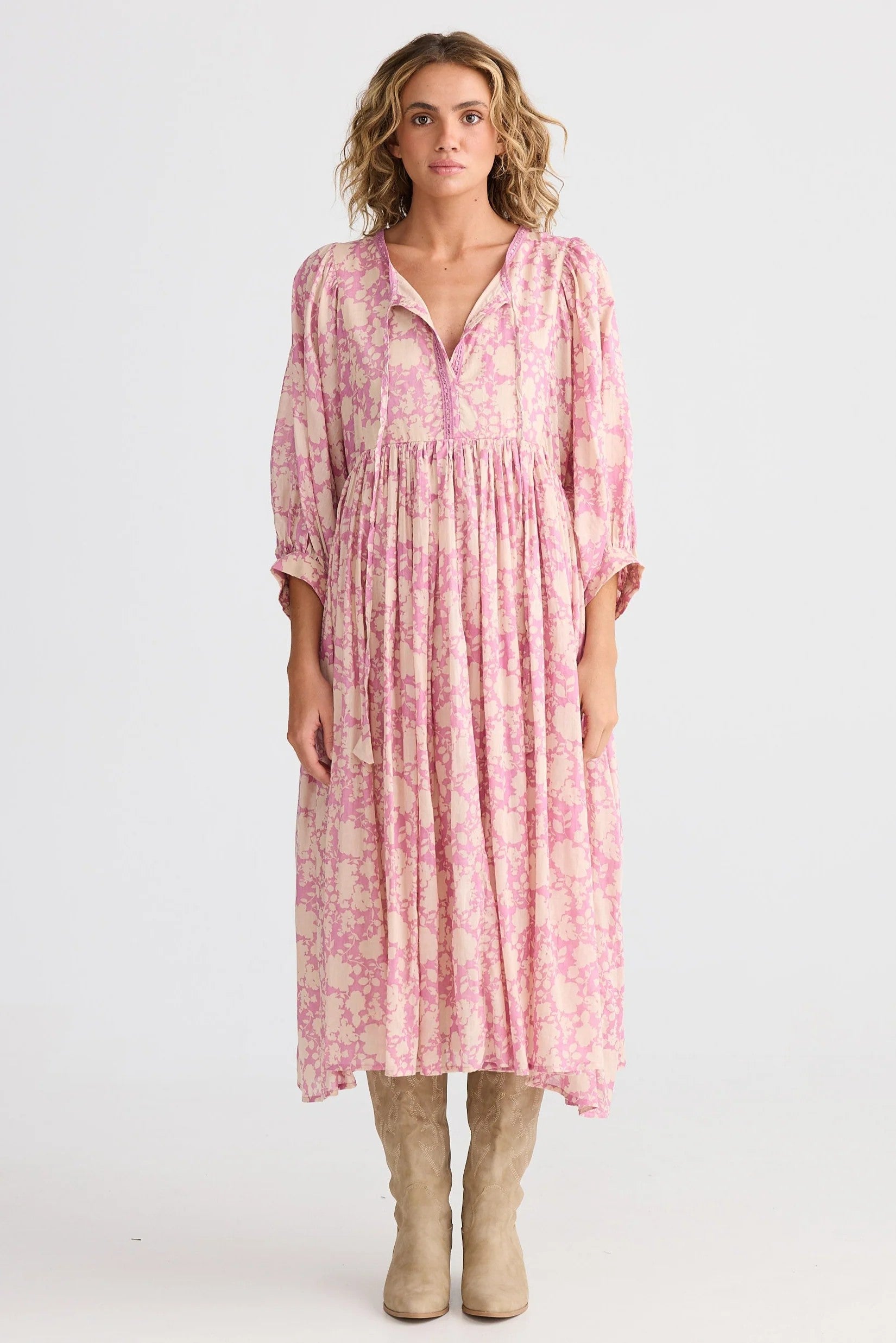 Woman wearing a pink patterned dress on a white background