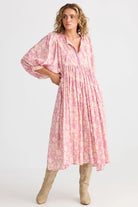 Woman wearing a pink floral dress on a white background