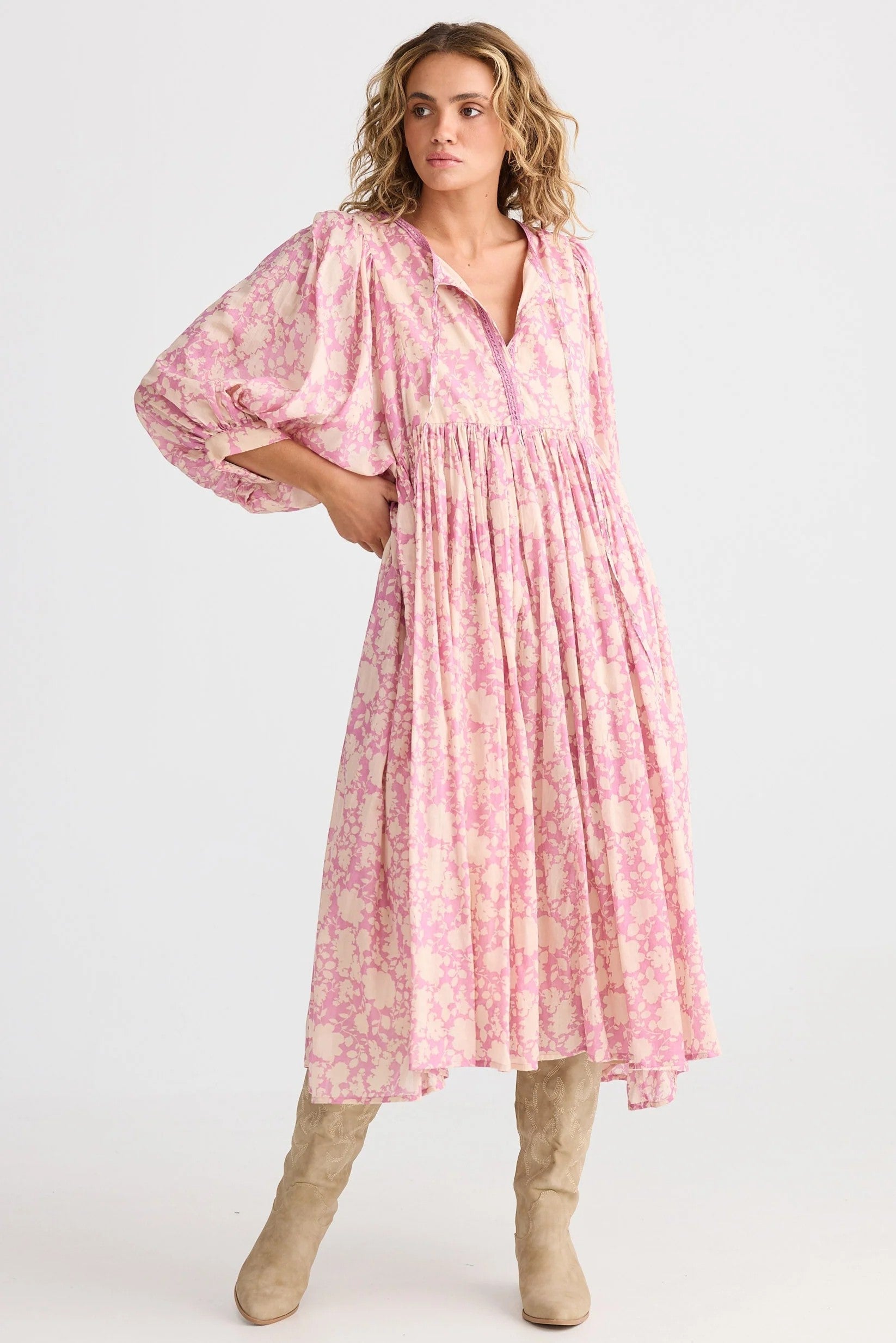 Woman wearing a pink floral dress on a white background