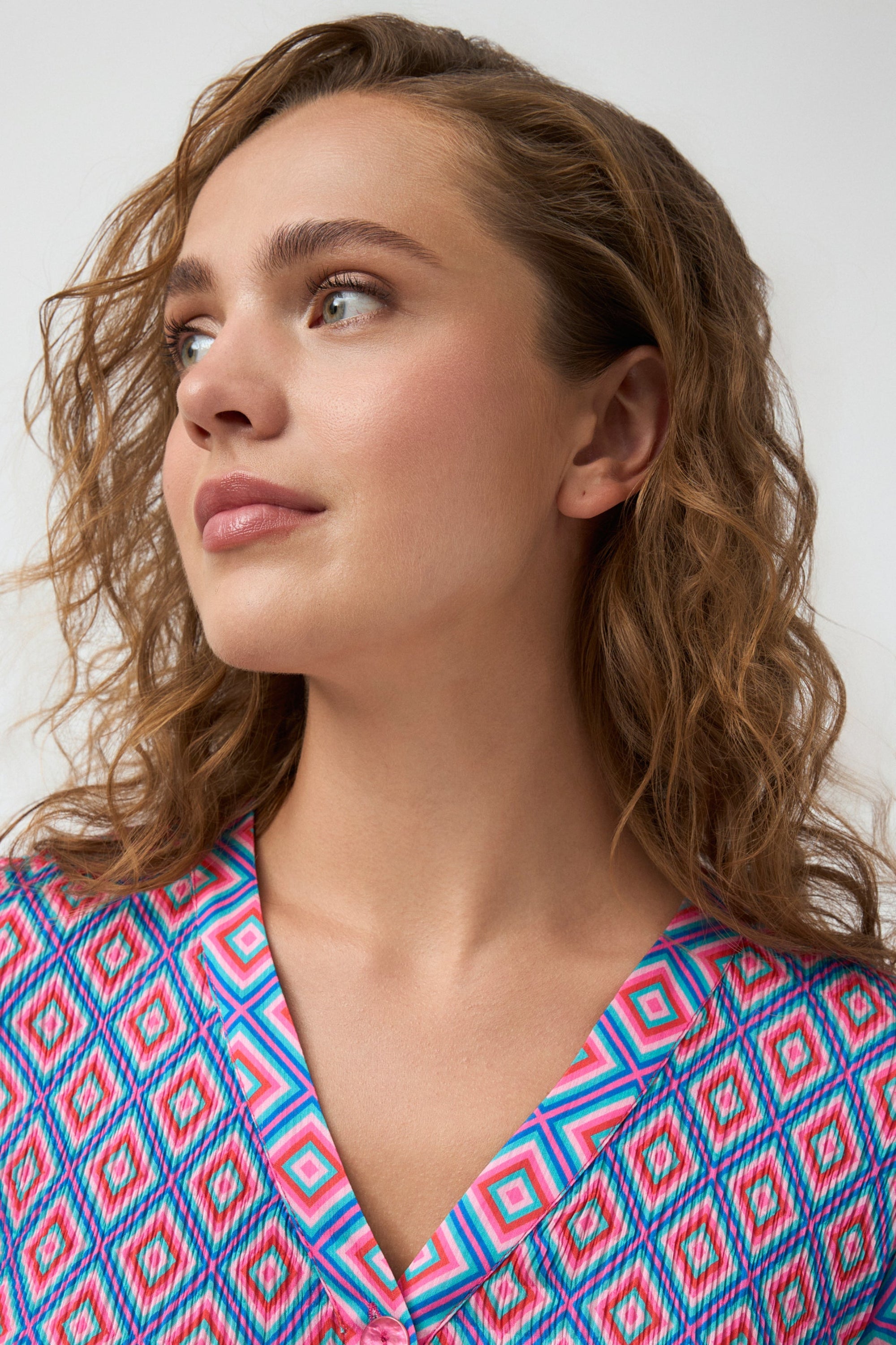 geometric print blouse in pink and blue worn by model close up
