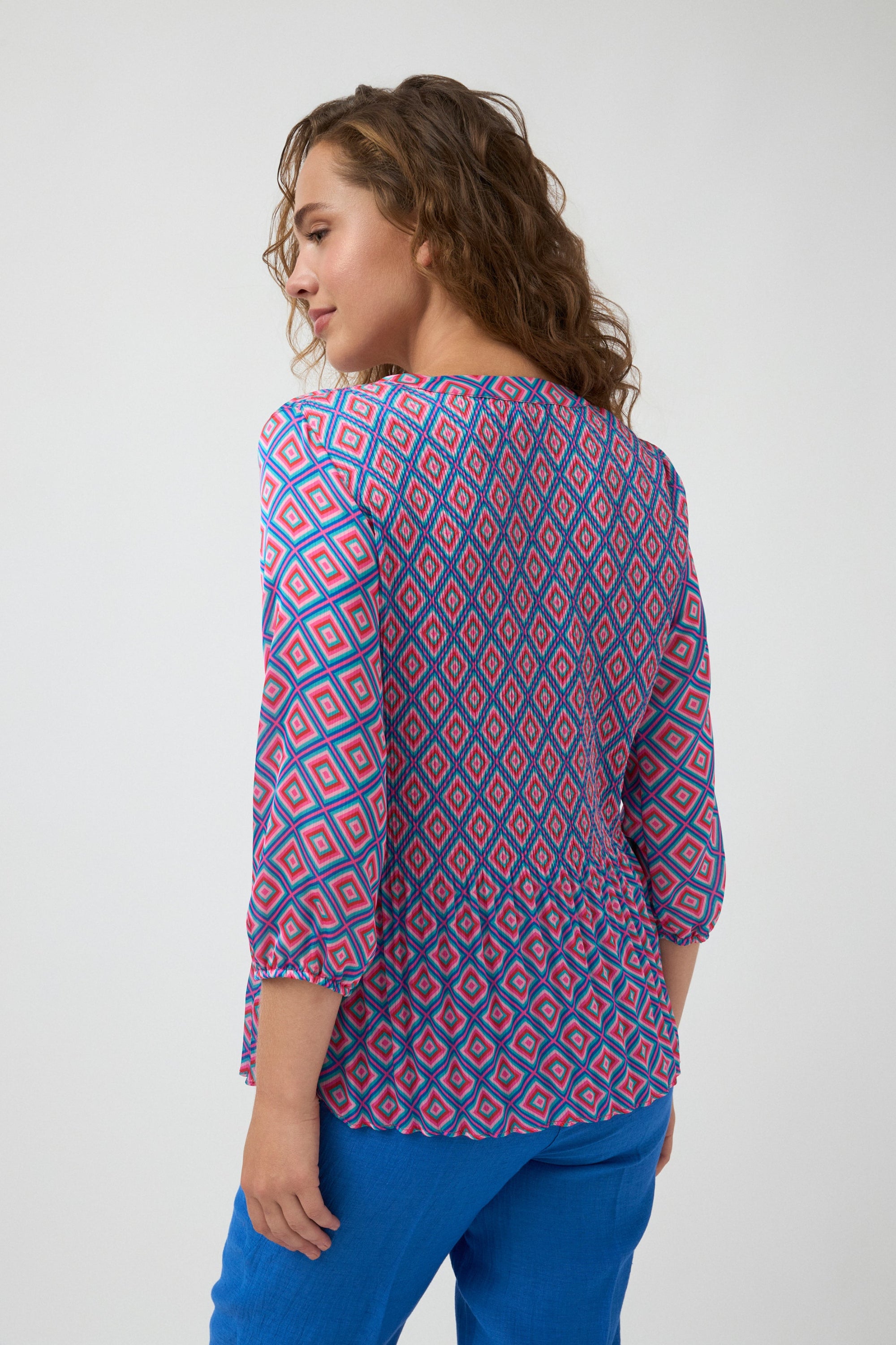 geometric print blouse in pink and blue worn by model back view